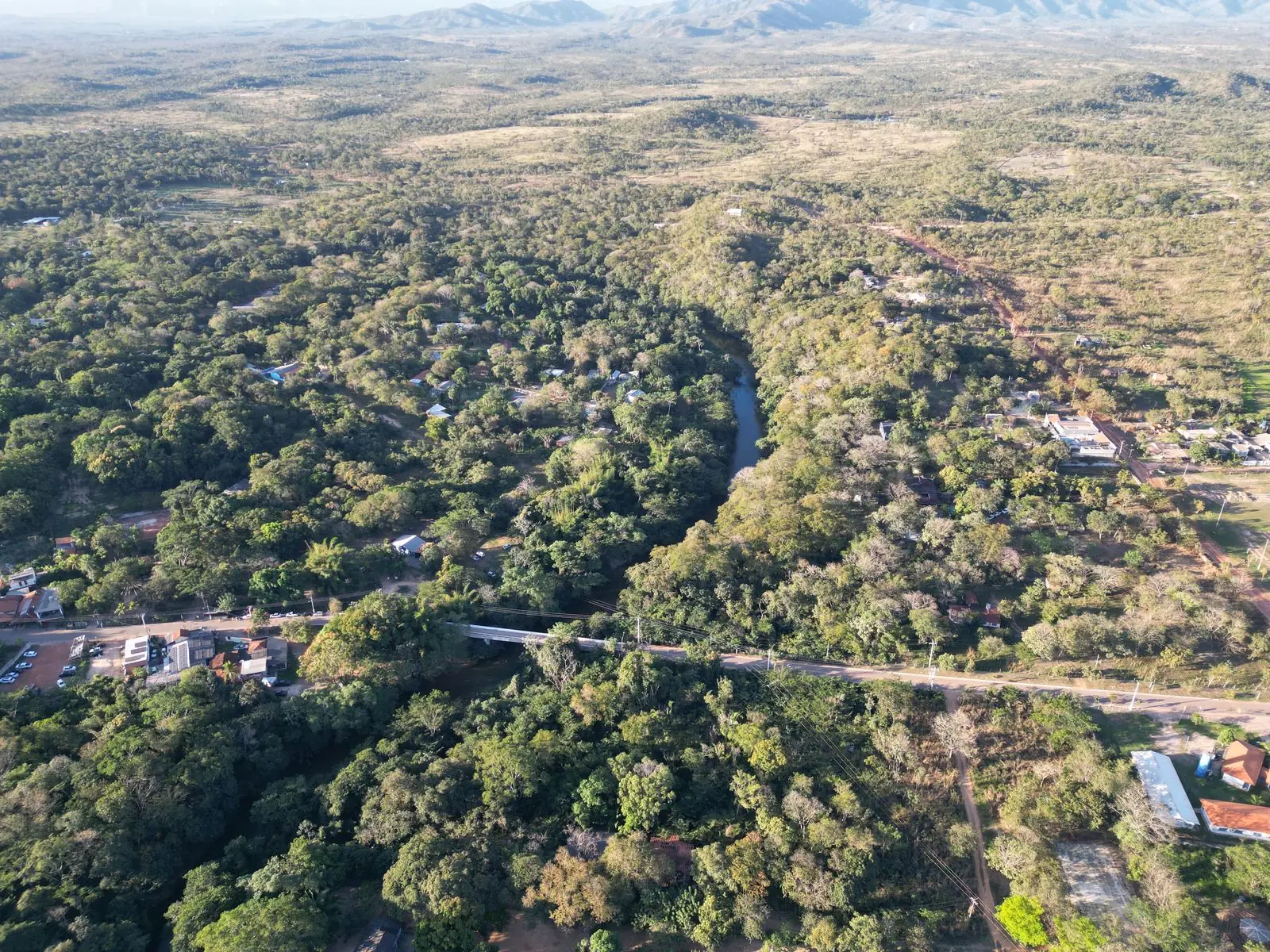 Vista aérea da região da Chácara Namastê, com o rio cortando a mata