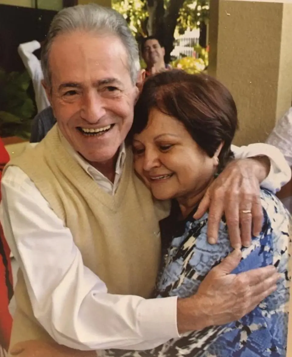 Pais da Sita Madhu, Maria Helena e Sandoval, abraçados e sorrindo