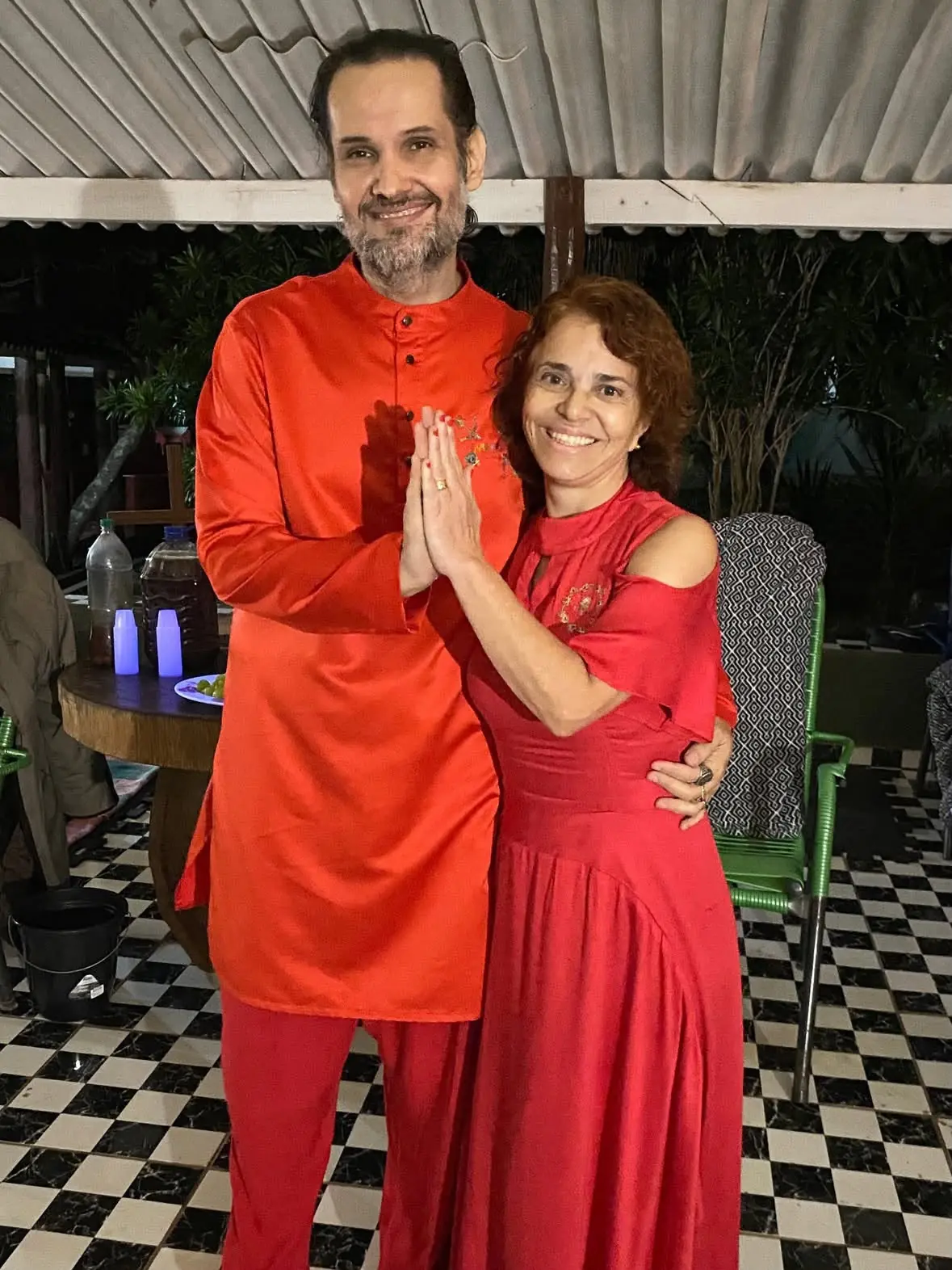 Sita Madhu e Rama Krishna de mãos unidas em saudação, vestidos de vermelho e laranja